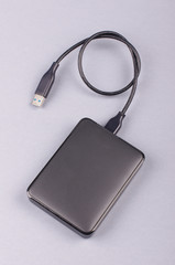 Fototapeta na wymiar External 2.5'' hard drive HDD isolated on the gray background