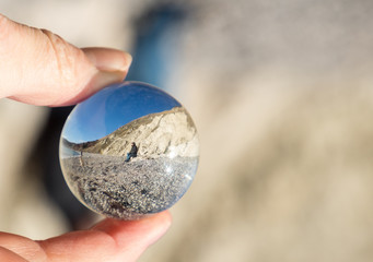 looking at scene through glass bll on sunny day at beach