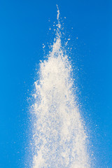 water splashing from the fountain in the background of blue sky