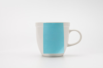 Stick blue paper on white mug isolated on white.