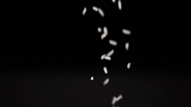 rice falls on a solid black surface