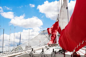 Bowsprit and gathered red sail of the sailing ship.