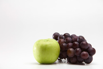 Green apple and grape on a white 