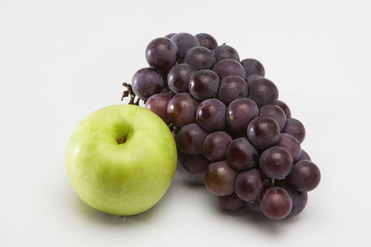 Green apple and grape on a white 