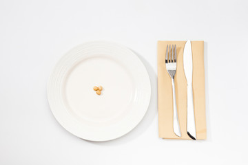 One Soybean on plate with fork and knife.