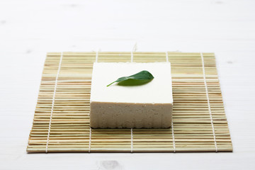 Tofu made from soybeans at green leaf decorated 