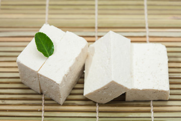 Tofu made from soybeans at green leaf decorated 
