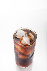 Cola with ice in a glass on white background