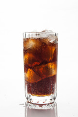 Cola with ice in a glass on white background