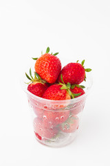 Plastic cup with strawberries on a white 
