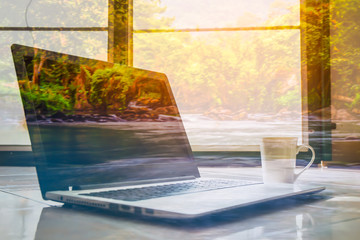 double exposure laptop and coffee cup with blur gill in forest b