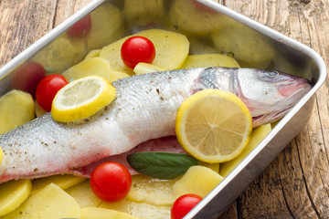 Fish with lemon potatoes and tomatoes ready for the oven