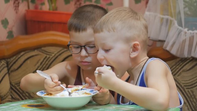 Children eat with appetite at the table.