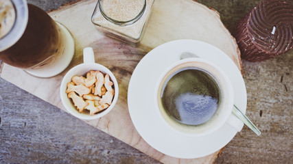 cup of coffee on old wooden desk. Simple workspace or coffee break in morning/ selective focus