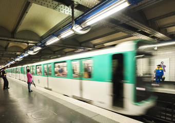 Paris Metro Train approaching a station at speed.