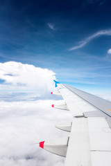 Fototapeta na wymiar Wing of an airplane flying above clouds