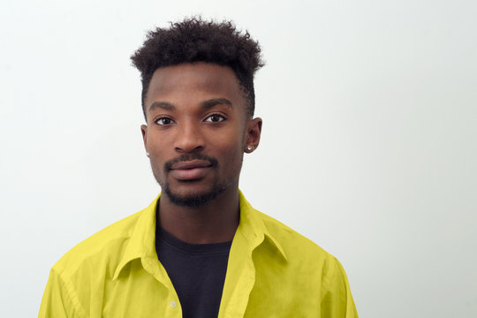 Young Man Around Twenty Wearing Yellow Shirt On White Background