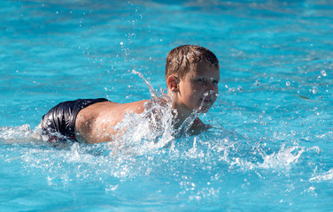 boy swims with a splash in the water park