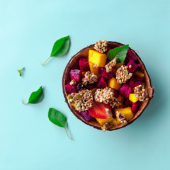 Healthy vegetariam sweet breakfast concept. Still life of colorful smoothie with granola and tropical fruits in glass jar.