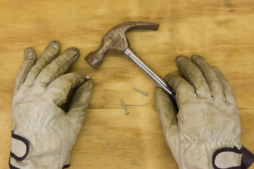 top view gloves with hammer on wooden background
