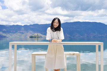 年轻女性站在白色长桌后面看镜头微笑, 云南丽江泸沽湖