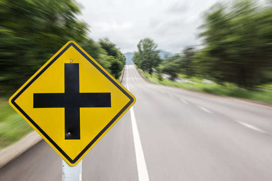 Intersection Ahead Sign On Blur Road Background