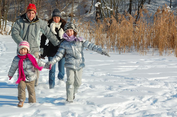 Fototapeta na wymiar Happy family in winter, having fun with snow outdoors on weekend 