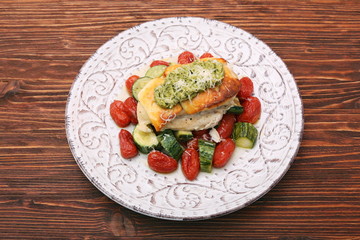 Fototapeta na wymiar Baked chicken breasts which basil pesto sauce, tomatoes, and che