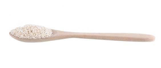 Wooden spoon with sesame seeds on a white background