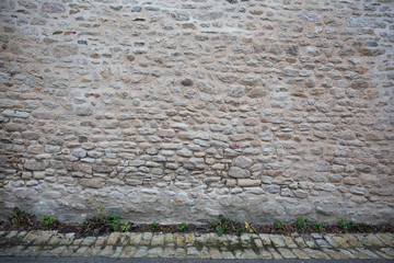 In the village street, an ancient stone wall with the floor down