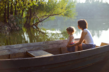 Mother and daughter sailing in a wooden boat.
