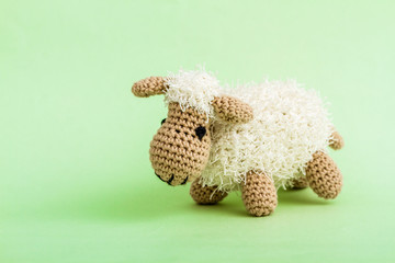 Handmade Crochet Lamb Toy on Green Background.