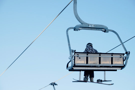 Snowboarder sitting on the chairlift