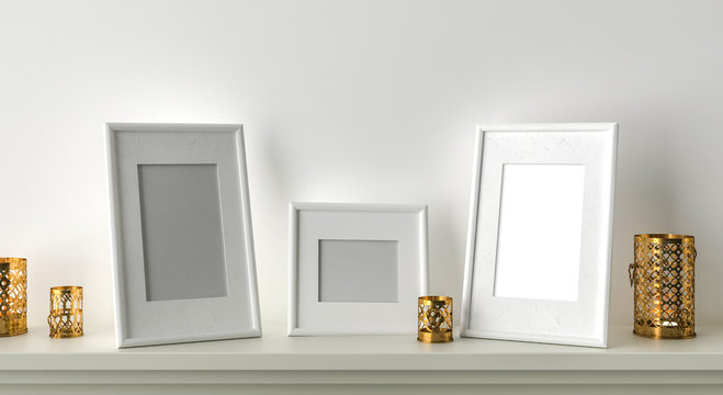 Three blank picture frame with candles on fireplace