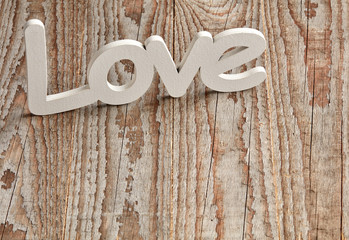 White love sign on wooden table with heart confetti