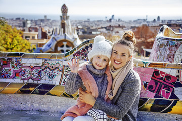 Fototapeta premium matka i dziecko w Barcelonie handwaving siedząc na ławce