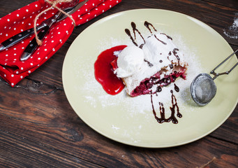 Christmas cherry strudel with ice cream on wood table