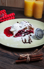 Christmas cherry strudel with ice cream on wood table