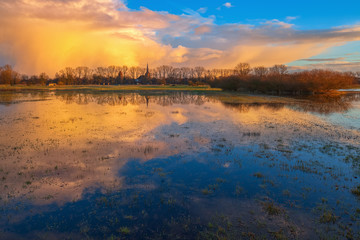 Goldene Wolken / Wolkenspiegelung auf einer Wiese bei Dannenberg (Landkreis Lüchow-Dannenberg, Niedersachsen). Aufgenommen während der goldenen Stunde vor dem Sonnenuntergang vom 24. Februar 2016.