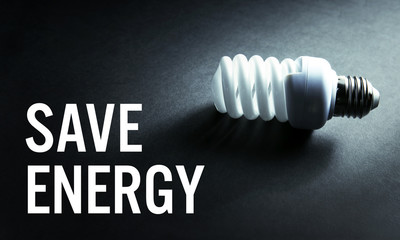 Light bulb and text SAVE ENERGY on dark background