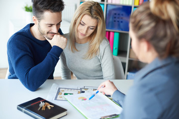 Couple visiting estate agents office .