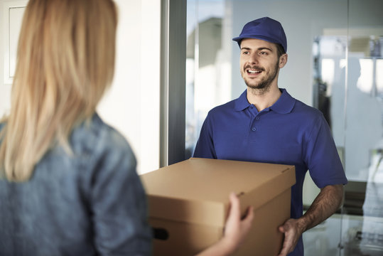 Delivery man handing box to woman