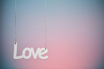 Obraz na płótnie Canvas White love sign hanged on pink and blue background