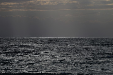 sunset in winter, cloudy sky, sun ray in the sea of clouds