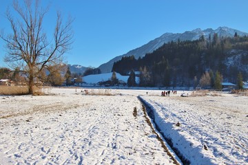 Winter landscape with frozen lake in Goldegg, Austria, Europe. People walk and do sport on the lake. In January 2017.