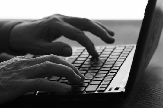 old woman typing on a laptop