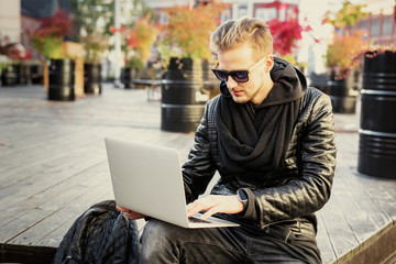 Stylish man using portable computer in the city