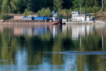 near Malmyzh, Russia - September 3, 2009: The car ferry sails away from the coast to cross the Vyatka River