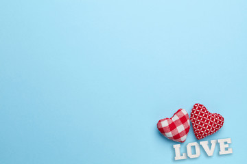 Plain blue background with two little, red heart and love word