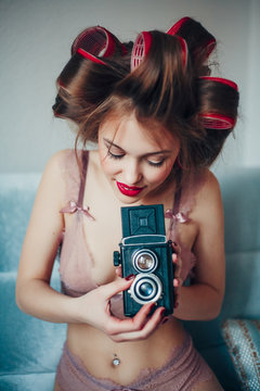 Beauty portrait of young woman holding vintage camera